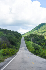 Road to mountain - A long straight road leading towards a nature green tree on the mountains , Asphalt road in Thailand