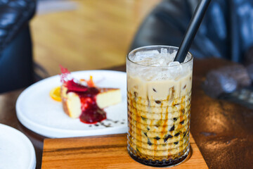 Bubble milk tea in glass on the wooden table with cake - Taiwan milk tea