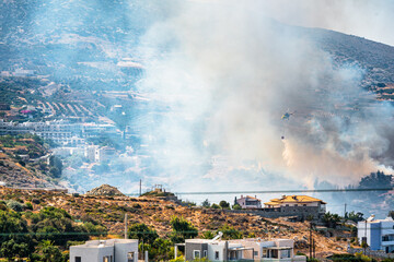 Mountain area and village in fire, smoke in the air. 