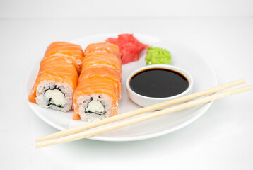 philadelphia maki rolls with soy sauce, pink ginger, wasabi on white background, asian food, japanese cuisine