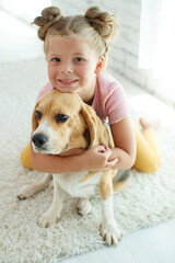 Child with a dog. Little girl plays with a dog at home. Child and animal. High quality photo.