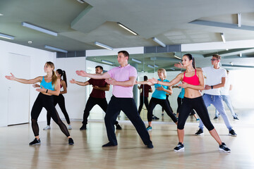 Happy different ages adults training swing steps at dance class