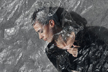 Young woman in plastic foil