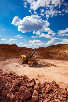 Aluminium ore mining. Bauxite clay Open-cut mining. Excavator loading ore to dump truck. Arkalyk, Kazakhstan.
