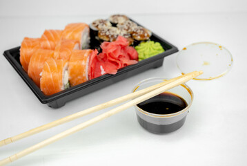 take away sushi in plastic containers, philadelphia rolls and unagi maki, soy sauce, pink ginger, wasabi, sushi delivery concept