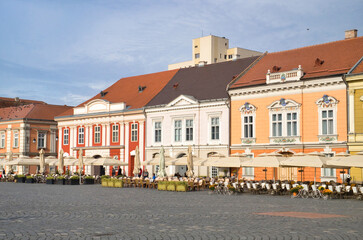 Old historic architecture and lonely homeless man on the Unirii square of Timisoara, Romania
