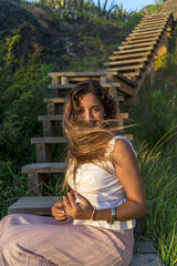 Vertical shot of a beautiful Caucasian female posing outdoors on windy day