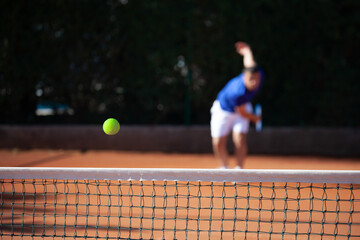 Tennis ball just over the net after powerful first serve of a player