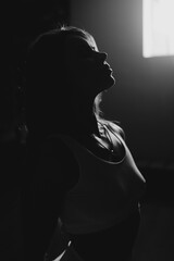 Silhouette of woman in jeans denim jacket and white sport bra.