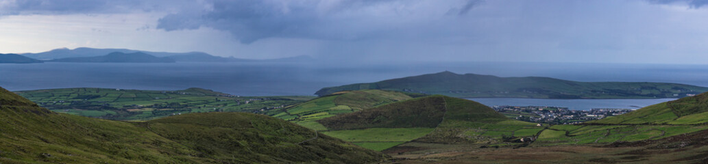 Fototapeta na wymiar Panorama of Dingle town and surrounding green hilly farmland on the west coast of Ireland.