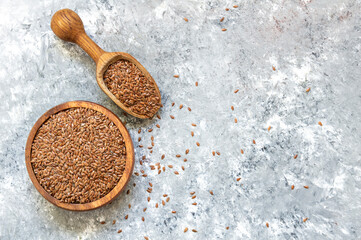 Heap of Flax seeds or linseeds in spoon or bowl on rustic background. Flaxseed concept, dietary fiber background