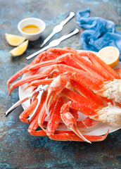 Snow crab legs plate with lemon and butter sauce, selective focus © Y. A. Photo