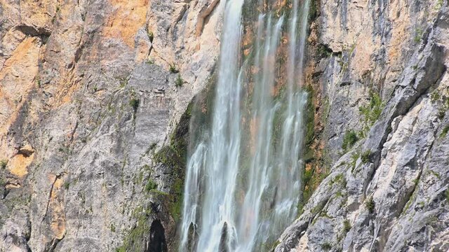 Waterfall Boka in Slovenia. Water gently flowing down the rocks. Moss growing under waterfall. Static, close up, real time