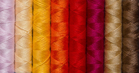 background of multi-colored spools of thread closeup