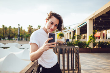 Half length portrait of cheerful influence blogger creating media content via mobile application...