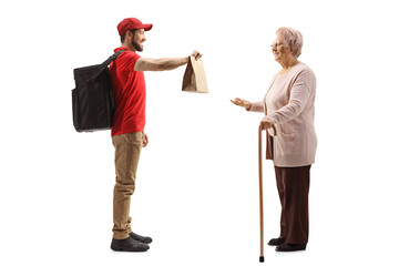 Full length profile shot of a guy delivering a food to an elderly lady