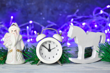 Christmas composition, pine branches and white Christmas toys and alarm clock