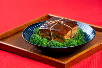 Dong Po Rou (Dongpo pork meat) in a beautiful blue plate with green broccoli vegetable, traditional...