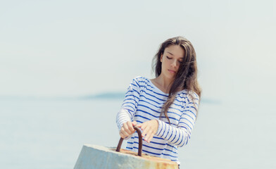 Woman in a striped T-shirt keeps near the breakwater.