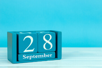 wooden calendar with the date of August 28 on a blue wooden background, International Safe Abortion...