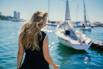 Woman in dress enjoys sea on the pier.