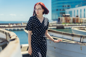 Young woman posing near old boat.
