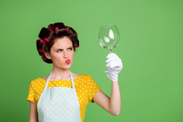 Photo of uncertain maid girl look wine glass check clean wear yellow dotted retro vintage style dress isolated over green color background