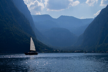 Beautiful scene of Sailing boat on Hallstatt lake and Alps in background 