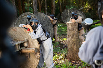 Fototapeta premium Two opposing teams of players shooting on paintball playing field outdoors