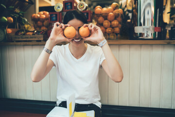 Portrait of cheerful female vegetarian having fun during snack time near sidewalk grocery, joyful...