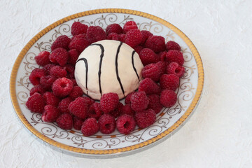 Plate with raspberries and cookies on a white background.