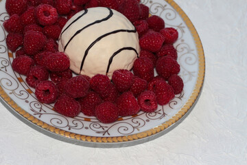 Plate with raspberries and cookies on a white background.