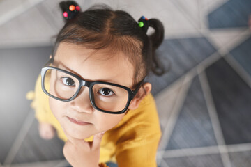 Cute little asian girl with thinking gesture looking at camera. Concept of child education