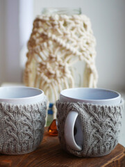 two white knitted mugs, insulation for mugs