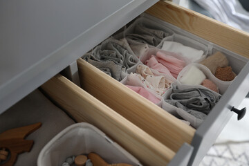 Fototapeta na wymiar Open cabinet drawer with clothes in child room