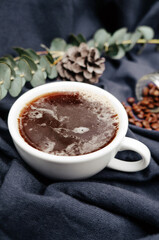 Smoke in black coffee cup Aromatic and coffee beans on the table, dark purple cotton background