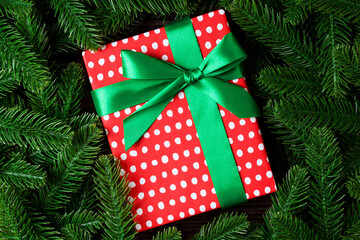 Top view of New Year gift box decorated with fir tree branch. Merry Christmas concept with empty space for your design