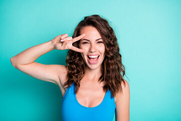 Photo of positive cheerful girl enjoy summer rest relax make v-sign face feel excited wear blue...