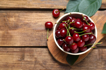 Sweet juicy cherries on wooden table, flat lay. Space for text © New Africa