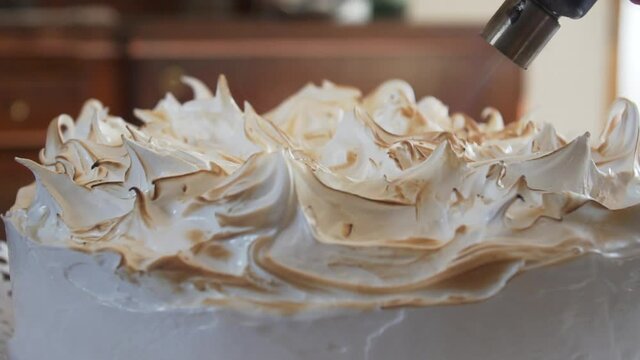 Close up on torch roasting meringue, slow motion