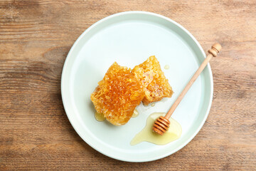 Tasty honey and combs on wooden table, top view