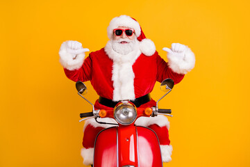 Fototapeta na wymiar Portrait of his he nice confident cheerful Santa riding moped pointing at himself St Nicholas December tradition isolated bright vivid shine vibrant yellow color background