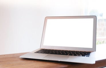 Fototapeta premium Laptop with blank screen on wooden table in front of office window technology