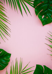 Tropical green leaves on a pink background. Minimal nature summer concept. Top view, copy-space.