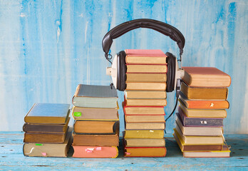 audio book concept with stacks of books and vintage headphones, good copy space