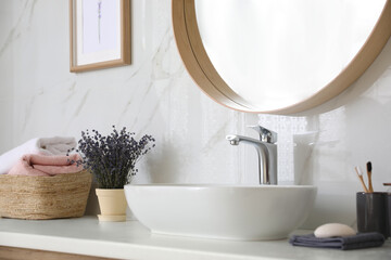 Naklejka na ściany i meble Bathroom counter with vessel sink, flowers and towels in bathroom interior. Idea for design