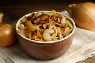 Tasty fried onion in bowl on napkin, closeup