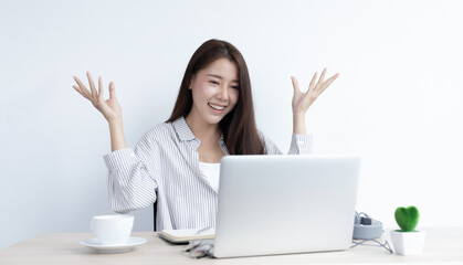Young Asian woman works on paperwork in her own home online.
