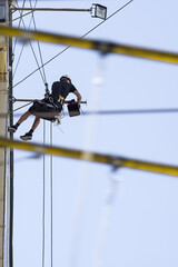 Industrial climbing. A construction worker abseiling and suspending in safety ropes. Washing windows, cleaning walls, maintenance.