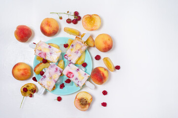 fresh summer ice cream on a stick with peach and raspberry berries . on a light background top view . ice cream ingredients ripe peaches and raspberries with yogurt